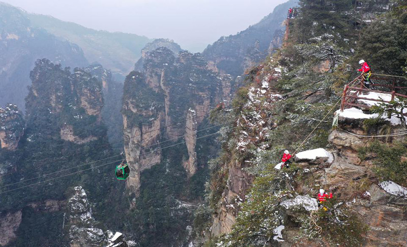 Durante una sesión de entrenamiento, miembros del equipo de rescate de emergencia se ofrecieron como voluntarios para recoger basura en rocas y acantilados del sitio turístico Wulingyuan de Zhangjiajie, provincia de Hunan, febrero del 2022. [Foto: Wu Yongbing/ China Daily]