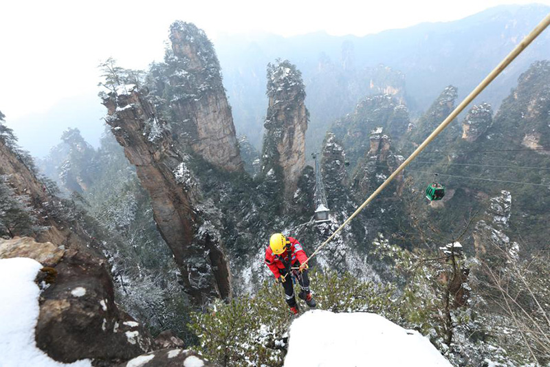 Durante una sesión de entrenamiento, miembros del equipo de rescate de emergencia se ofrecieron como voluntarios para recoger basura en rocas y acantilados del sitio turístico Wulingyuan de Zhangjiajie, provincia de Hunan, febrero del 2022. [Foto: Wu Yongbing/ China Daily]