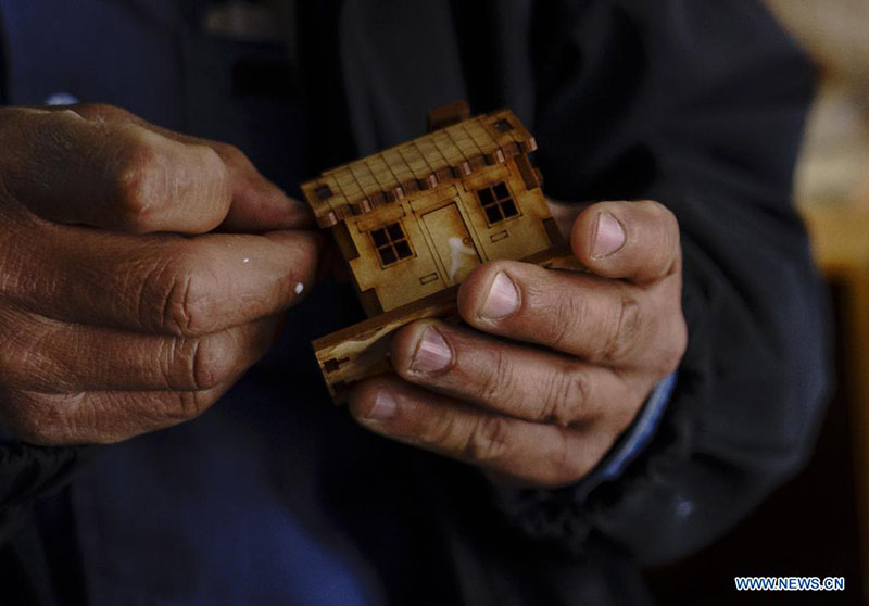 Nelson Gálvez arma piezas de una figura a escala en su taller de artesanías, en Quito, capital de Ecuador, el 20 de marzo de 2022. Hernando Gálvez y su hermano Nelson Gálvez emprendieron hace 19 a?os su taller de artesanías Taller Sin Fronteras en el que fabrican con madera tríplex estructuras patrimoniales a escala de Ecuador. (Xinhua/Santiago Armas)