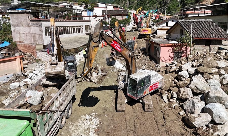 Vista aérea tomada con un dron el 5 de agosto de 2024 de trabajadores de emergencia despejando una sección de la carretera nacional No. 318 afectada por una inundación repentina y un alud de lodo, en la aldea de Ridi de la ciudad de Kangding, en la provincia de Sichuan, en el suroeste de China. (Xinhua/Liu Kun) 