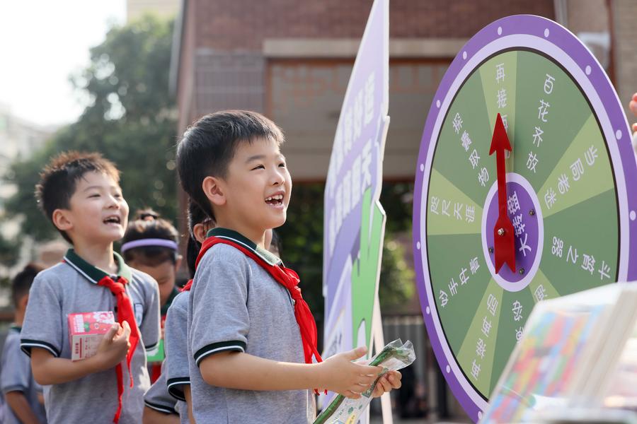 Un joven escolar gira una rueda de la suerte en una escuela primaria de Hefei, provincia oriental china de Anhui, el 1 de septiembre de 2024. (Fotografía de Xie Chen/Xinhua). 